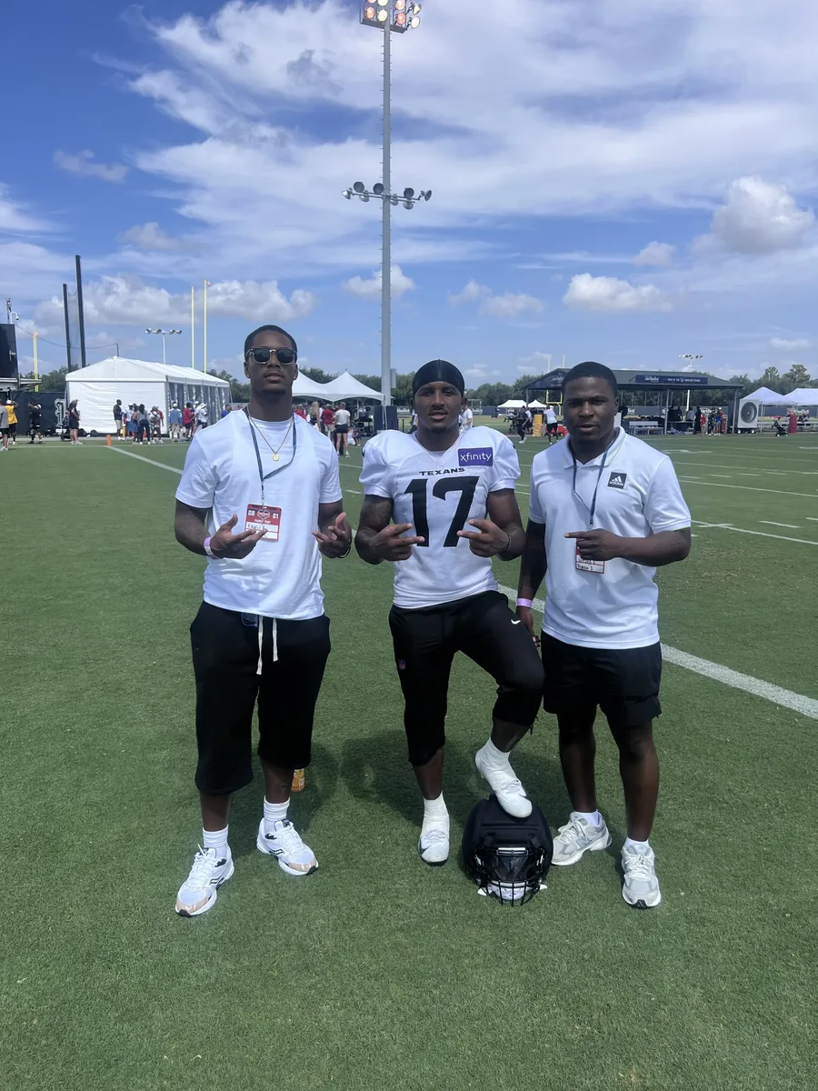 Three men on the field at Houston Texans training camp